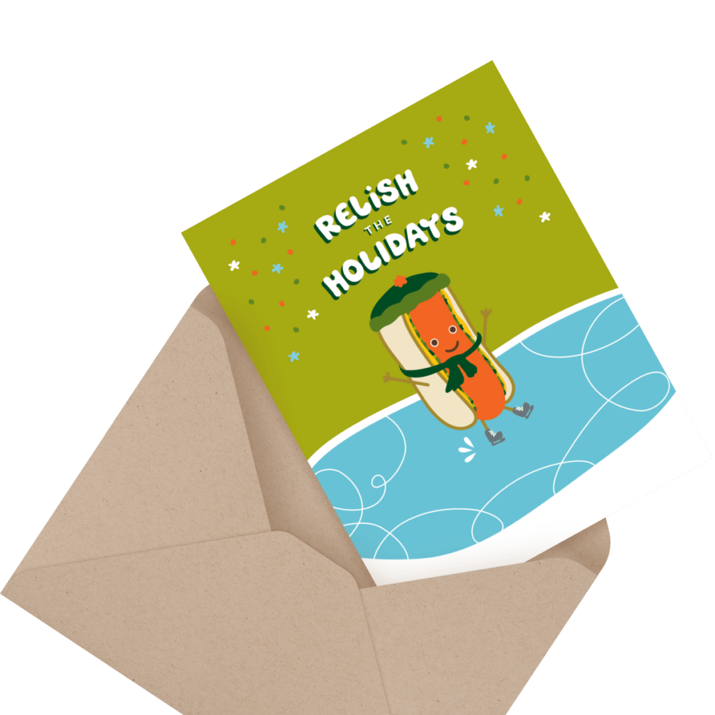 Greeting card with a hot dog cartoon character skating, wearing a green hat and scarf. Text reads "Relish the Holidays." The card is partially inside a kraft paper envelope.