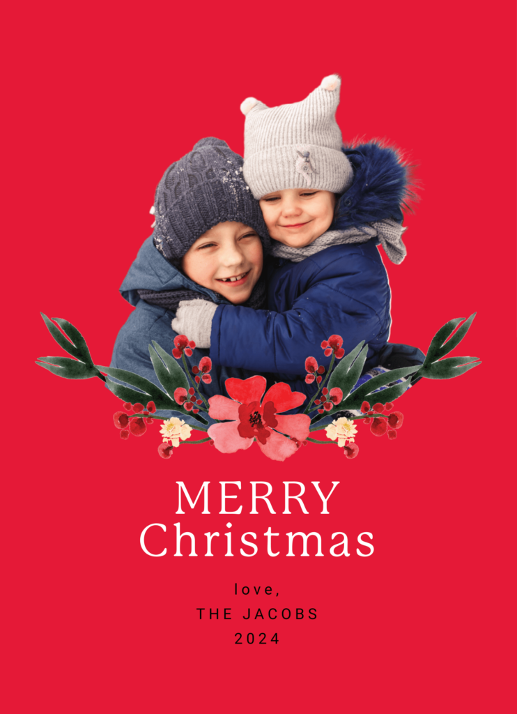 Two children in winter clothing hug on a red background, with floral decorations and "Merry Christmas, love, The Jacobs 2024" written below.