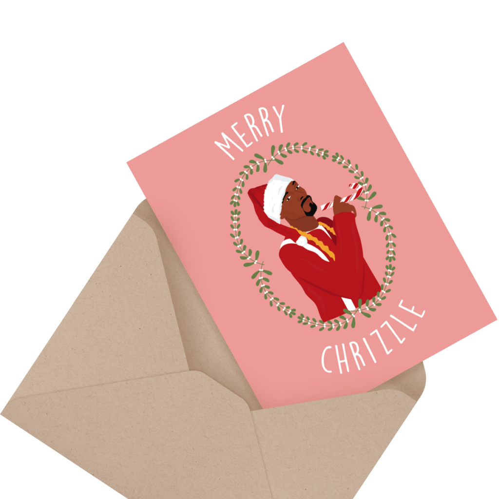 Greeting card with a cartoon figure dressed as Santa on a pink background, captioned "Merry Chrizle," placed on a brown envelope.