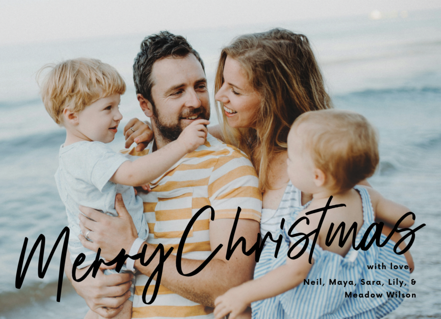 A man and woman holding two children on the cover of a Postable Christmas card.