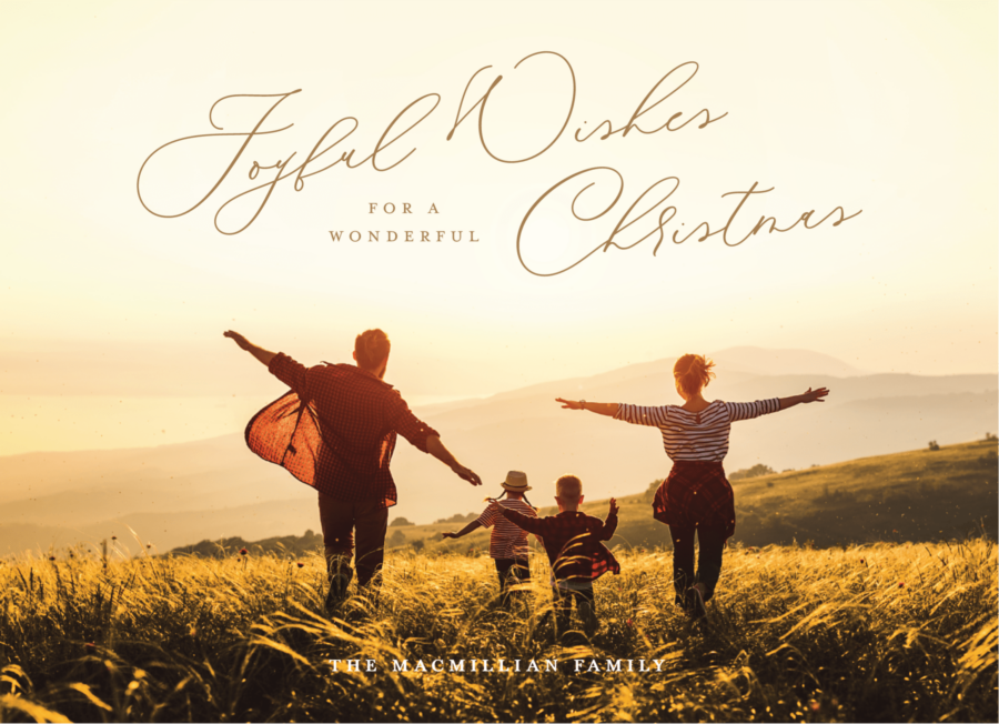 Family of four joyfully running through a grassy field at sunset, with "Joyful Wishes for a Wonderful Christmas" written in elegant script above.