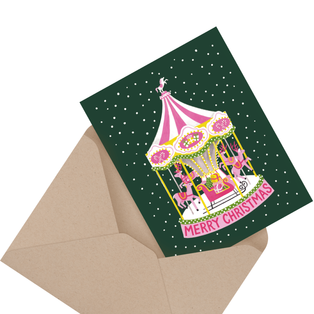 A Christmas card with a pink and white carousel design inside an envelope. The card reads "Merry Christmas" and features a green background with white polka dots resembling snow.